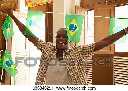 Stock Image - Students celebrating with Brazilian flags. Fotosearch