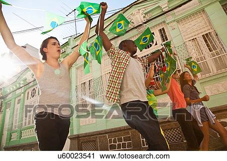 Stock Image - "Students celebrating with Brazilian flags in the street, Rio de Janeiro, Brazil". Fotosearch
