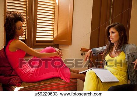 Stock Image - Students chilling out and studying in living room. Fotosearch