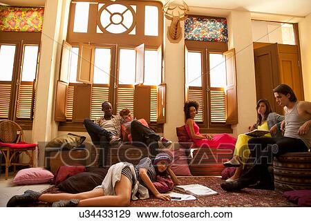 Students chilling out and studying in living room View Large Photo Image Stock Photo - Students chilling out and studying in living room. Fotosearch