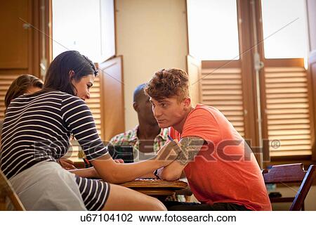 Stock Image - Students relaxing in living room. Fotosearch