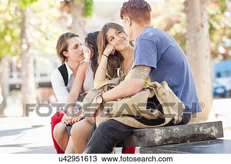 Stock Image - Students sitting under tree. Fotosearch