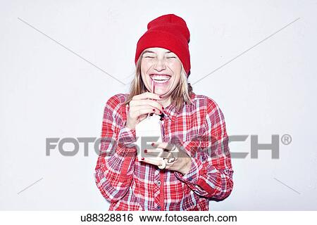 Studio portrait of young woman in red hat drinking juice View Large Photo Image Stock Photograph - Studio portrait of young woman in red hat drinking juice. Fotosearch