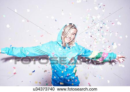 Studio portrait of young woman throwing confetti View Large Photo Image Stock Image - Studio portrait of young woman throwing confetti. Fotosearch