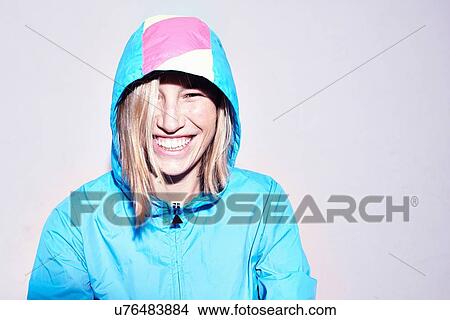 Studio portrait of young woman wearing turquoise hooded anorak View Large Photo Image Picture - Studio portrait of young woman wearing turquoise hooded anorak. Fotosearch