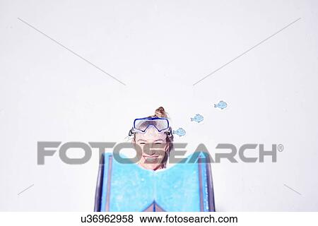 Stock Photo - Studio portrait of young woman with flipper foot wearing swimming goggles. Fotosearch