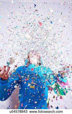 Studio shot of young woman and explosion of confetti View Large Photo Image Stock Image - Studio shot of young woman and explosion of confetti. Fotosearch