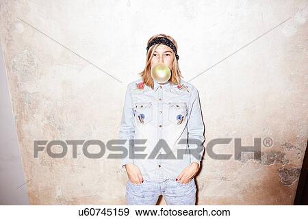 Studio shot of young woman blowing yellow bubble gum bubble View Large Photo Image Stock Photo - Studio shot of young woman blowing yellow bubble gum bubble. Fotosearch
