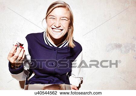 Studio shot of young woman eating chocolate marshmallows View Large Photo Image Stock Image - Studio shot of young woman eating chocolate marshmallows. Fotosearch