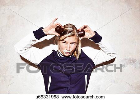 Studio shot of young woman making devil horns with chocolate marshmallows View Large Photo Image Stock Photo - Studio shot of young woman making devil horns with chocolate marshmallows. Fotosearch