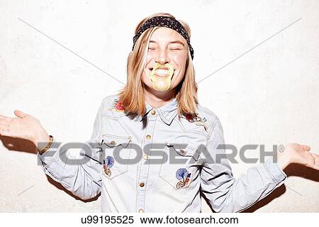 Studio shot of young woman with mouth covered in yellow gum bubble View Large Photo Image Stock Photography - Studio shot of young woman with mouth covered in yellow gum bubble. Fotosearch