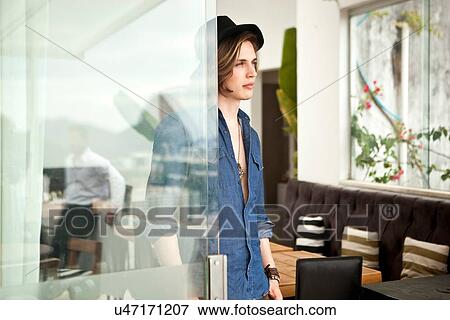 Stylish young man looking out from hotel lobby View Large Photo Image Stock Photo - Stylish young man looking out from hotel lobby. Fotosearch