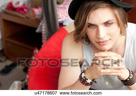 Stock Photo - Stylish young man sitting in hotel room. Fotosearch