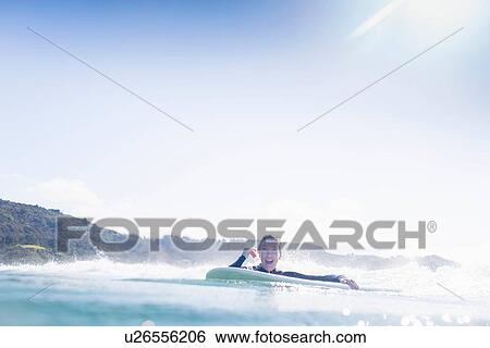Stock Photograph - "Surfer in the water, Bay of Islands, New Zealand". Fotosearch