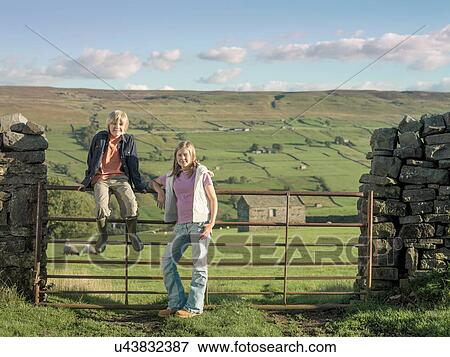 Teenage girl and brother at gate in rural landscape View Large Photo Image Stock Photo - Teenage girl and brother at gate in rural landscape. Fotosearch