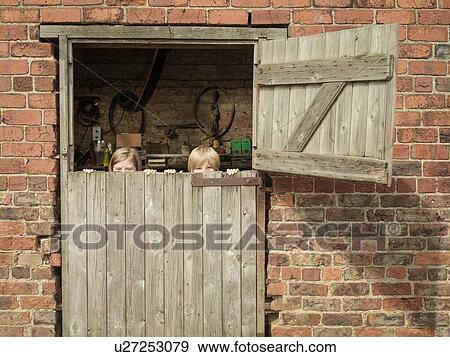 Teenage girl and brother hiding behind barn door View Large Photo Image Stock Photo - Teenage girl and brother hiding behind barn door. Fotosearch