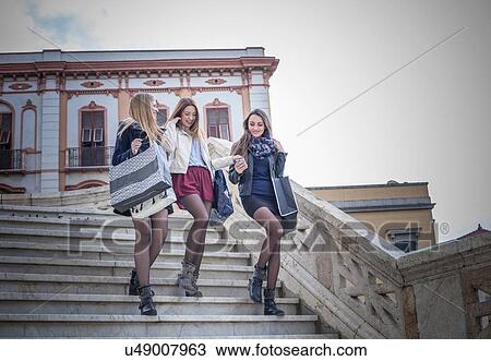 "Three female friends moving down stairway with shopping bags, Cagliari, Sardinia, Italy" View Large Photo Image Stock Image - "Three female friends moving down stairway with shopping bags, Cagliari, Sardinia, Italy". Fotosearch