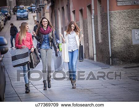 "Three female friends strolling along street with shopping bags, Cagliari, Sardinia, Italy" View Large Photo Image Stock Photo - "Three female friends strolling along street with shopping bags, Cagliari, Sardinia, Italy". Fotosearch