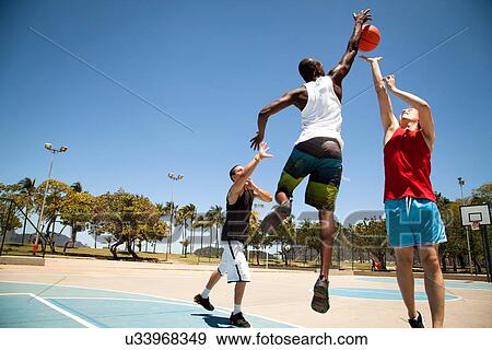 Stock Photo - Three man basketball team practicing on basketball court. Fotosearch
