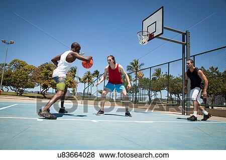 Three men practicing basketball on basketball court View Large Photo Image Stock Photo - Three men practicing basketball on basketball court. Fotosearch