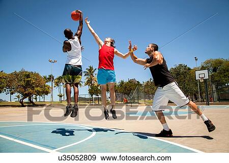Three men practicing on basketball court View Large Photo Image Stock Photo - Three men practicing on basketball court. Fotosearch