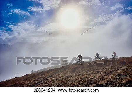 "Three people mountain biking, Valais, Switzerland" View Large Photo Image Picture - "Three people mountain biking, Valais, Switzerland". Fotosearch