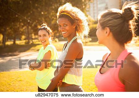Stock Photography - Three smiling young women training in park. Fotosearch