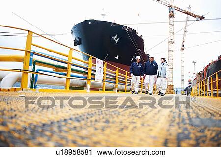 "Three workers at shipping port, low angle view, GoSeong-gun, South Korea" View Large Photo Image Stock Image - "Three workers at shipping port, low angle view, GoSeong-gun, South Korea". Fotosearch