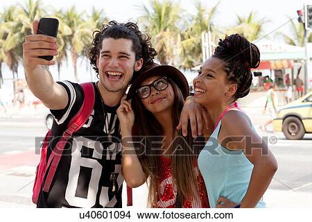 "Three young adult friends posing for smartphone selfie, Copacabana, Rio De Janeiro, Brazil" View Large Photo Image Picture - "Three young adult friends posing for smartphone selfie, Copacabana, Rio De Janeiro, Brazil". Fotosearch