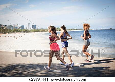 "Three young women jogging on beach, Rio De Janeiro, Brazil" View Large Photo Image Stock Image - "Three young women jogging on beach, Rio De Janeiro, Brazil". Fotosearch