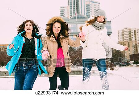 Three young women running in snow holding hands View Large Photo Image Picture - Three young women running in snow holding hands. Fotosearch