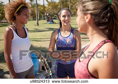 "Three young women, standing on field, talking" View Large Photo Image Stock Image - "Three young women, standing on field, talking". Fotosearch