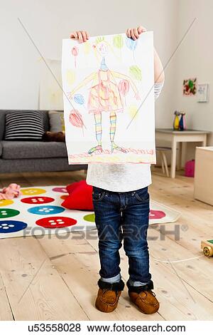 Stock Photo - Toddler holding up painting at home. Fotosearch