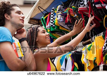 Stock Image - "Tourist couple browsing market stall, Copacabana town, Rio De Janeiro, Brazil". Fotosearch