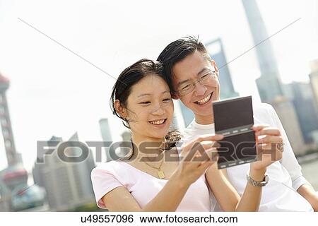 "Tourist couple looking at instant film photographs, The Bund, Shanghai, China" View Large Photo Image Stock Photograph - "Tourist couple looking at instant film photographs, The Bund, Shanghai, China". Fotosearch