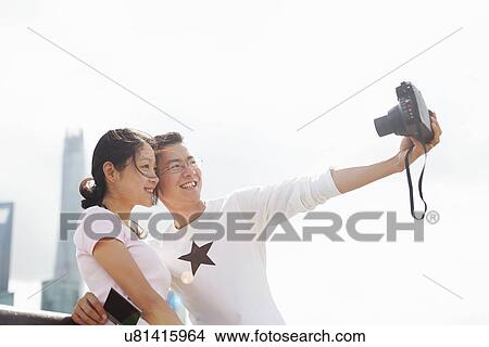 "Tourist couple taking instant camera selfie, The Bund, Shanghai, China" View Large Photo Image Picture - "Tourist couple taking instant camera selfie, The Bund, Shanghai, China". Fotosearch