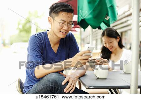 "Tourist couple using smartphones at sidewalk cafe, The Bund, Shanghai, China" View Large Photo Image Stock Image - "Tourist couple using smartphones at sidewalk cafe, The Bund, Shanghai, China". Fotosearch