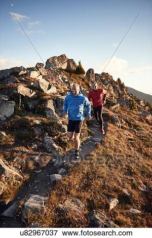 Stock Photo - "Trail runners on rocky path, Valais, Switzerland". Fotosearch