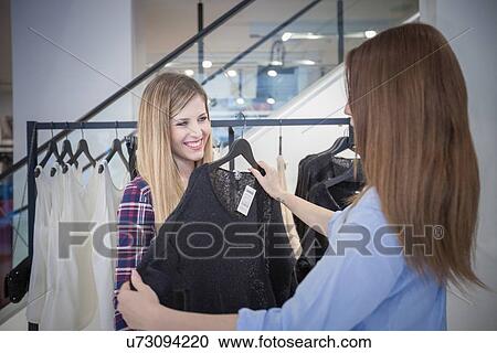 Two female friends shopping for sweater in boutique View Large Photo Image Stock Image - Two female friends shopping for sweater in boutique. Fotosearch
