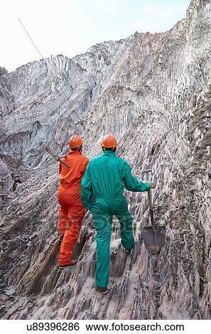 "Two male workers with digging tools, outside salt mine, rear view" View Large Photo Image Stock Photograph - "Two male workers with digging tools, outside salt mine, rear view". Fotosearch