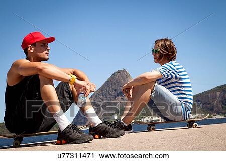 "Two men sitting on skateboards, relaxing" View Large Photo Image Stock Image - "Two men sitting on skateboards, relaxing". Fotosearch