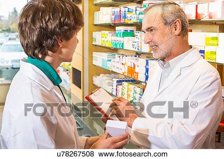 Two pharmacists checking medicines in pharmacy View Large Photo Image Stock Photo - Two pharmacists checking medicines in pharmacy. Fotosearch