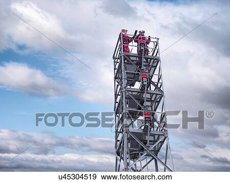 "Two tower workers on offshore radio tower on windfarm, low angle view" View Large Photo Image Stock Photo - "Two tower workers on offshore radio tower on windfarm, low angle view". Fotosearch