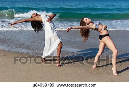 Two young female dancers poised bending backwards on beach View Large Photo Image Stock Photo - Two young female dancers poised bending backwards on beach. Fotosearch
