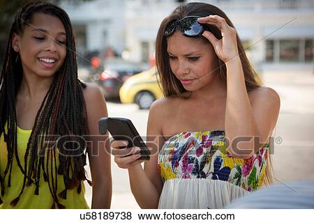 "Two young female friends reading texts on smartphone, Copacabana, Rio De Janeiro, Brazil" View Large Photo Image Stock Photo - "Two young female friends reading texts on smartphone, Copacabana, Rio De Janeiro, Brazil". Fotosearch