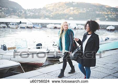 Picture - "Two young female friends strolling at Lake Como, Como, Italy". Fotosearch