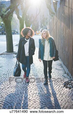 "Two young female friends strolling along street, Como, Italy" View Large Photo Image Stock Image - "Two young female friends strolling along street, Como, Italy". Fotosearch