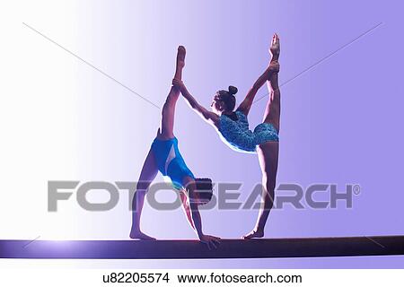 Two young gymnasts performing on balance beam View Large Photo Image Picture - Two young gymnasts performing on balance beam. Fotosearch