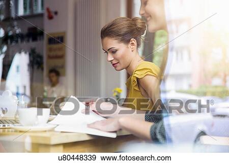 "Two young women having meeting in cafe, view through window" View Large Photo Image Stock Photo - "Two young women having meeting in cafe, view through window". Fotosearch