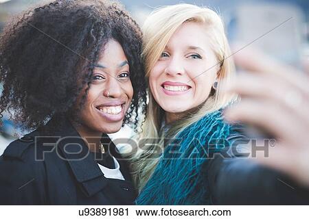 "Two young women posing for smartphone selfie, Lake Como, Como, Italy" View Large Photo Image Stock Image - "Two young women posing for smartphone selfie, Lake Como, Como, Italy". Fotosearch